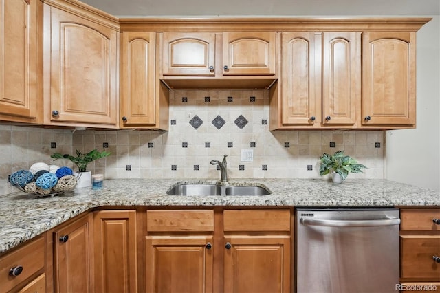 kitchen featuring stainless steel dishwasher, a sink, light stone countertops, and backsplash