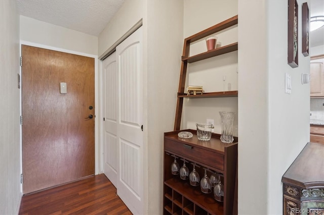 corridor featuring dark wood finished floors and a textured ceiling