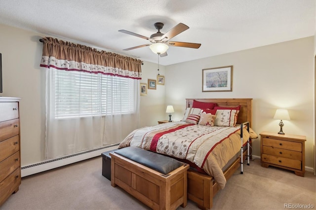 carpeted bedroom featuring a baseboard radiator and ceiling fan