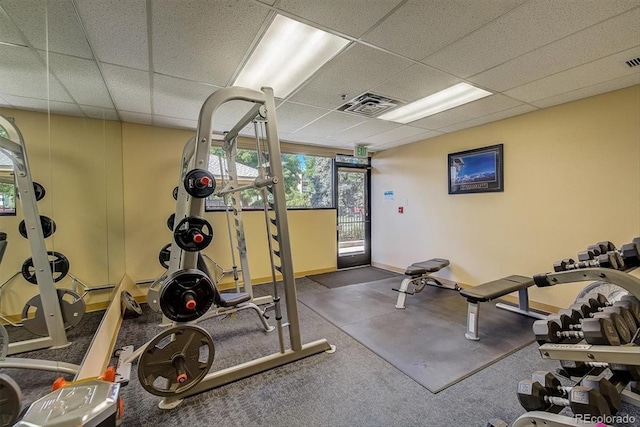 workout room with a drop ceiling and baseboards