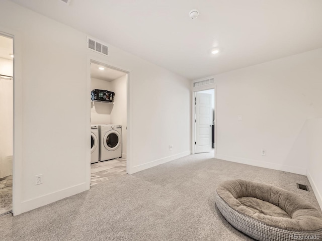 clothes washing area with separate washer and dryer and light colored carpet