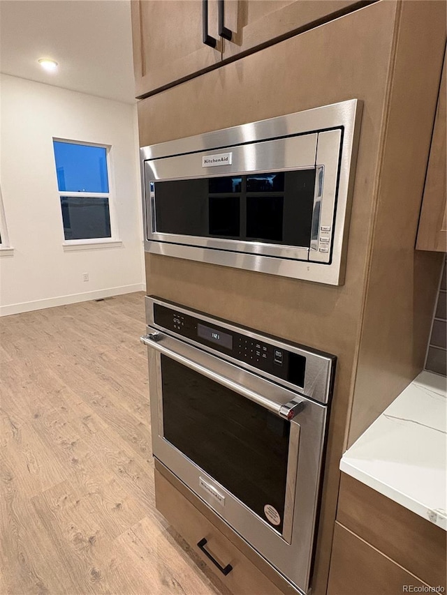 kitchen featuring appliances with stainless steel finishes and light hardwood / wood-style flooring