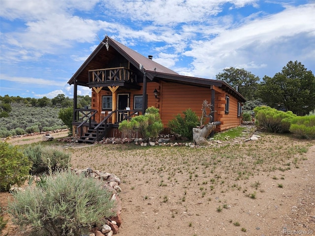 log cabin featuring a balcony