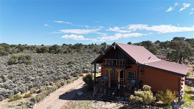 back of house with a balcony and covered porch