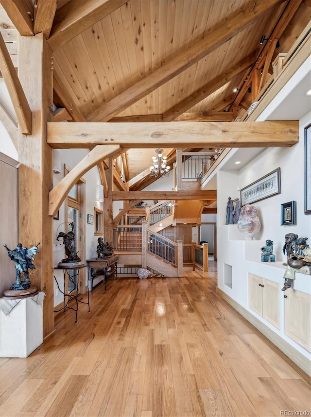 interior space featuring hardwood / wood-style floors, stairway, a chandelier, wood ceiling, and vaulted ceiling with beams