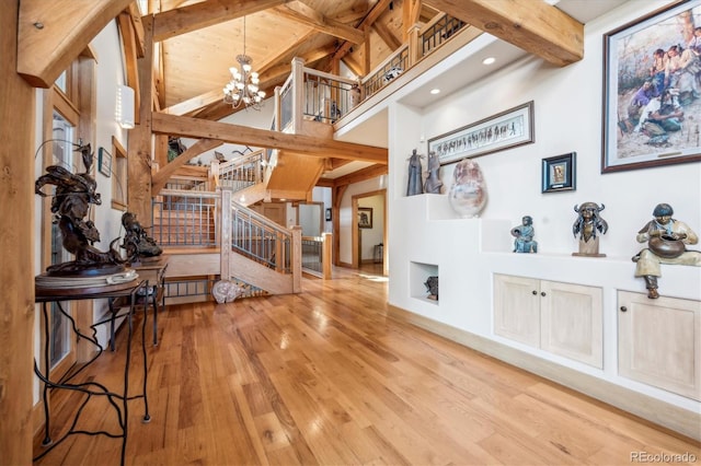 interior space with stairs, lofted ceiling with beams, wood finished floors, an inviting chandelier, and wood ceiling