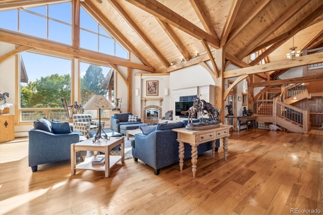 living area with light wood-type flooring, a wealth of natural light, and high vaulted ceiling