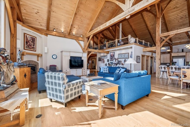 living room featuring wood ceiling, high vaulted ceiling, wood finished floors, beamed ceiling, and a fireplace