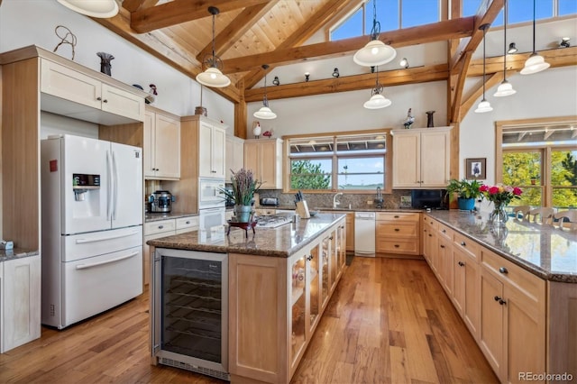 kitchen featuring wine cooler, white appliances, a peninsula, tasteful backsplash, and light wood-type flooring