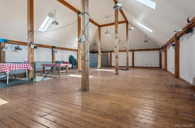 additional living space featuring hardwood / wood-style floors and vaulted ceiling with skylight