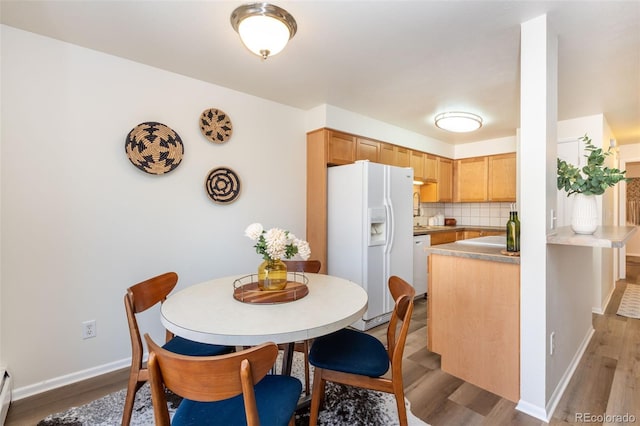 dining room with dark hardwood / wood-style flooring and a baseboard heating unit