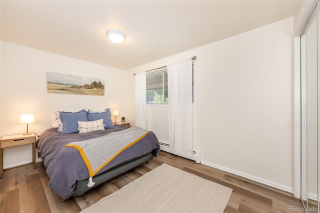 bedroom featuring hardwood / wood-style flooring and baseboard heating