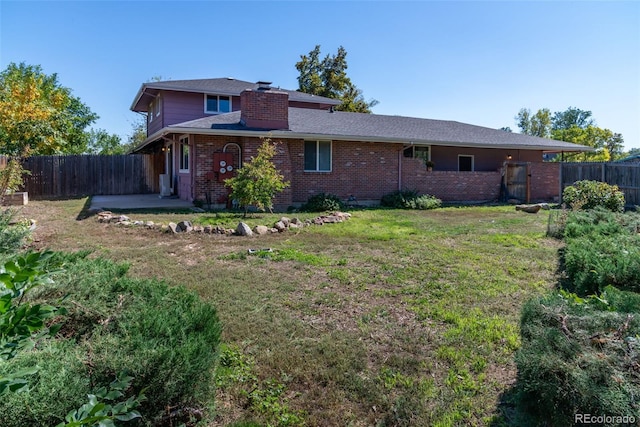 back of property featuring a patio area and a yard