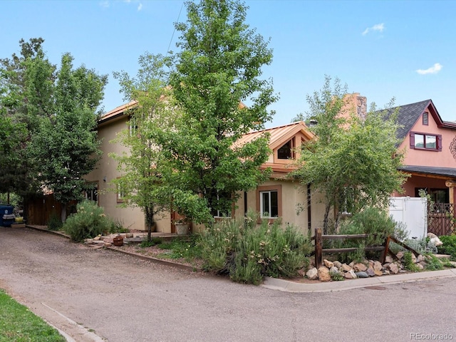 109 Bear Creek Ln, Morrison, CO 80465 - view of property hidden behind natural elements featuring stucco siding and a chimney