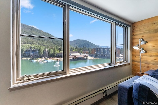 bedroom featuring wooden walls, a water and mountain view, and multiple windows