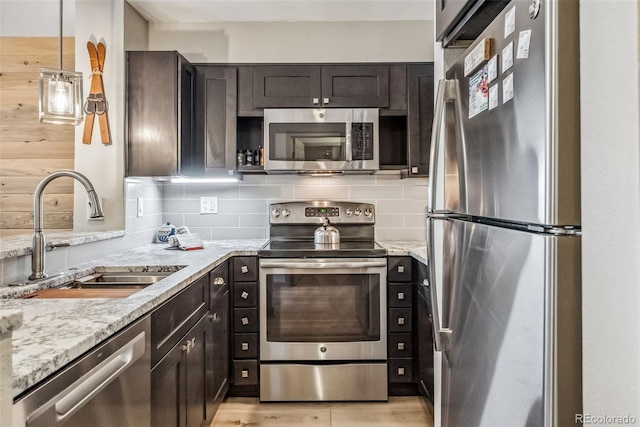 22174 US Highway 6 Unit 1535, Dillon, CO 80435 - kitchen with tasteful backsplash, a sink, dark brown cabinets, stainless steel appliances, and light stone counters