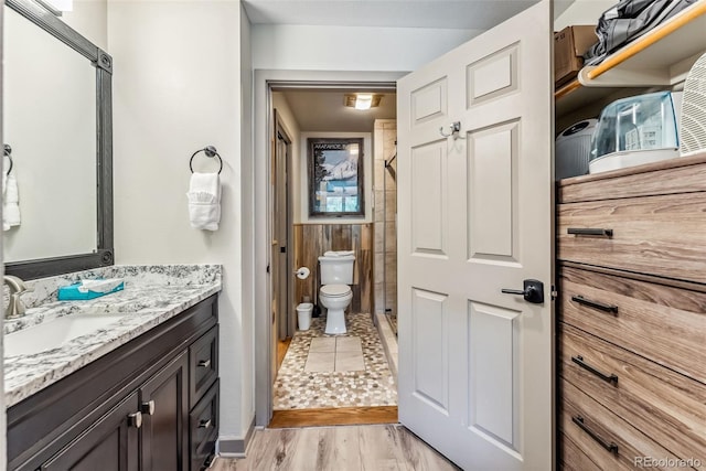 bathroom featuring walk in shower, vanity, toilet, and hardwood / wood-style flooring