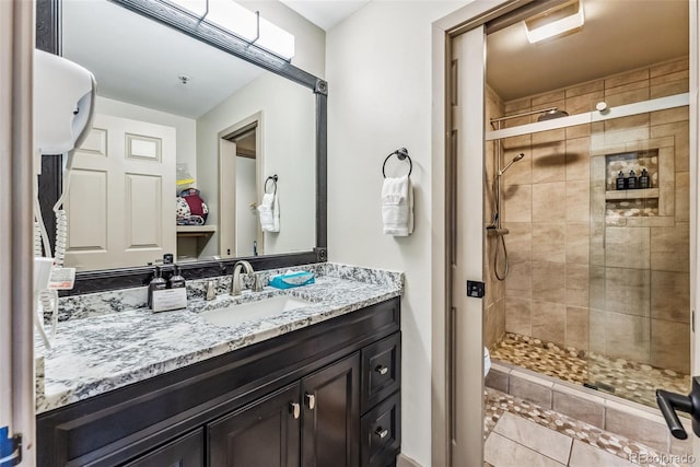 bathroom featuring tile patterned floors, an enclosed shower, and vanity