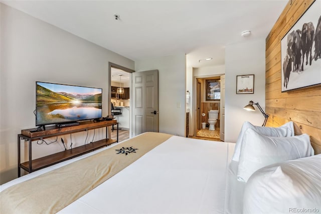 bedroom with wood walls and ensuite bathroom