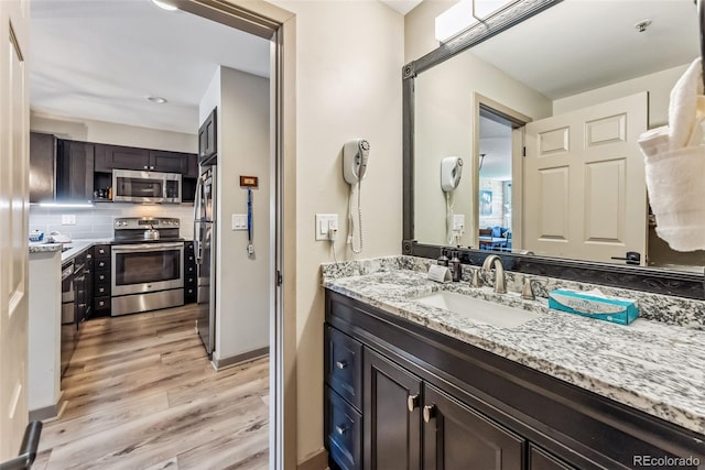 bathroom with wood-type flooring, backsplash, and sink