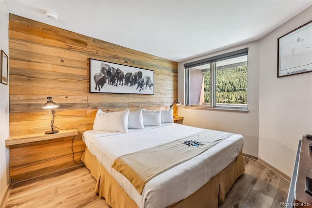 bedroom featuring wooden walls and hardwood / wood-style flooring