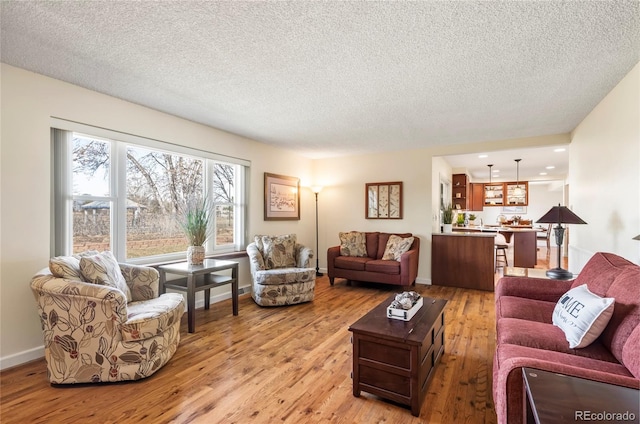 living room with a textured ceiling and light wood-style floors