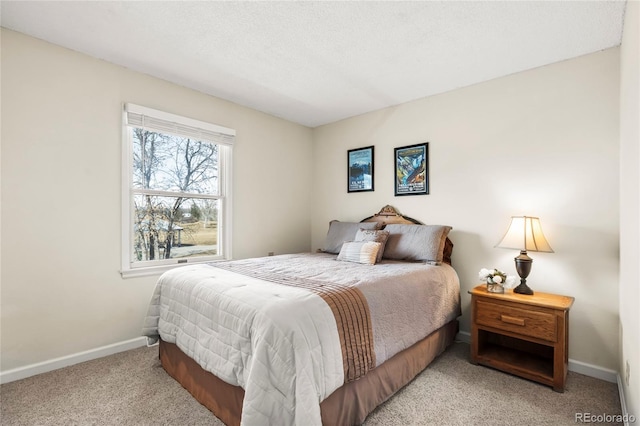 bedroom with light colored carpet, a textured ceiling, and baseboards