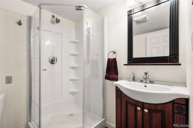 full bathroom with toilet, a shower stall, and vanity