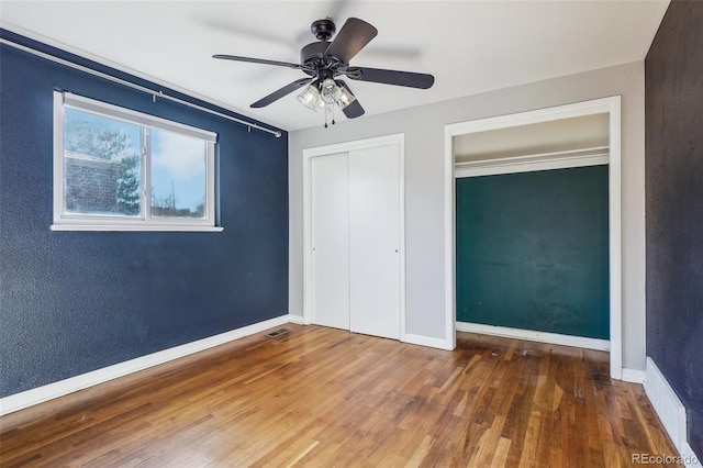 unfurnished bedroom with dark hardwood / wood-style flooring and ceiling fan