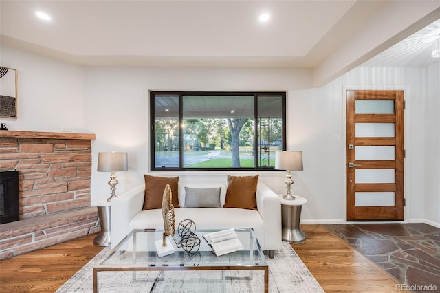 living room featuring hardwood / wood-style floors and a stone fireplace