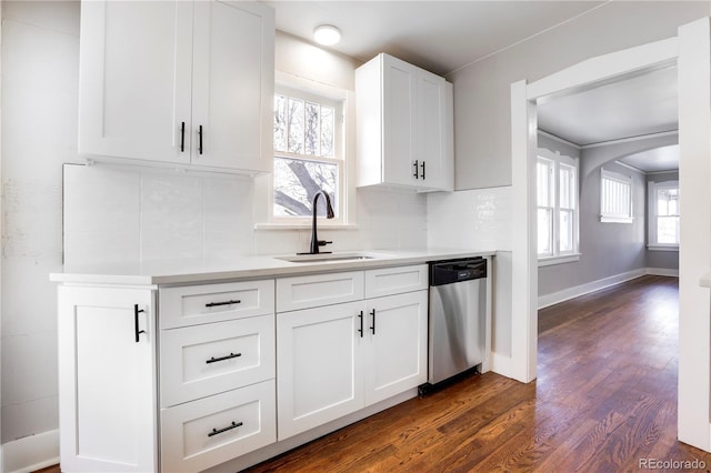 kitchen featuring sink, white cabinets, dark hardwood / wood-style flooring, backsplash, and stainless steel dishwasher