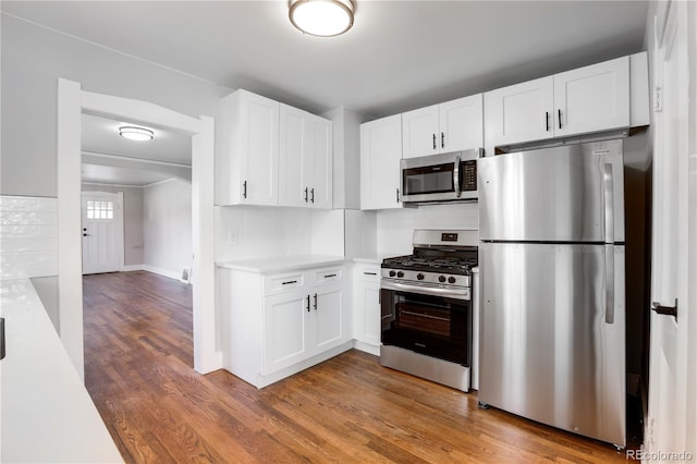 kitchen featuring hardwood / wood-style floors, white cabinets, and appliances with stainless steel finishes