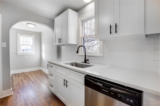 kitchen featuring dark hardwood / wood-style floors, tasteful backsplash, white cabinetry, dishwasher, and sink