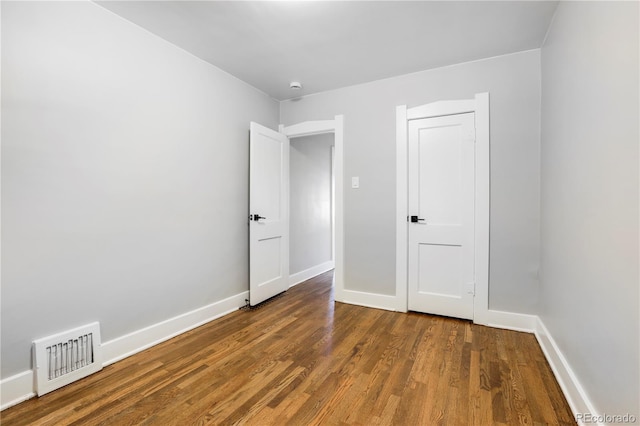 unfurnished bedroom with dark hardwood / wood-style flooring