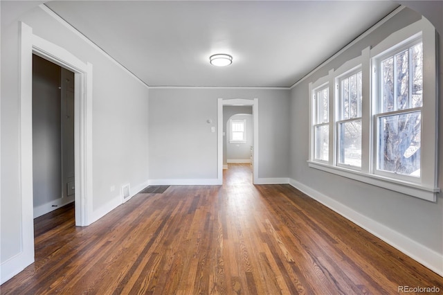 spare room featuring ornamental molding and dark hardwood / wood-style floors