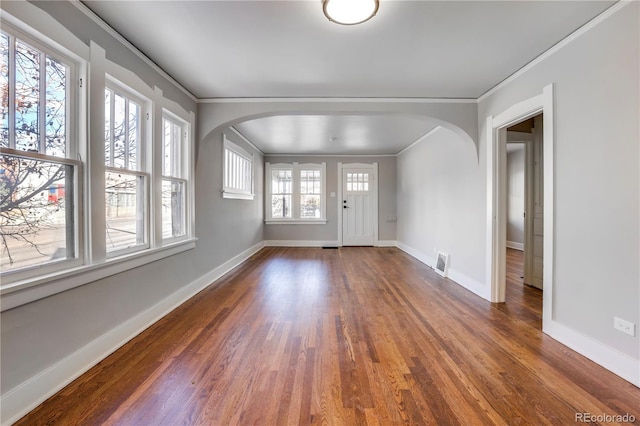 foyer entrance with ornamental molding and dark hardwood / wood-style floors