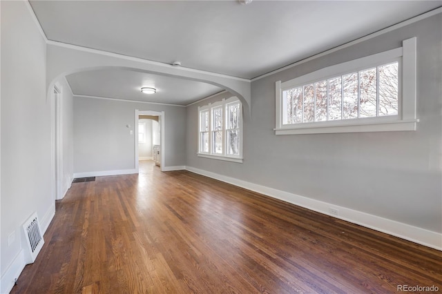 spare room featuring ornamental molding and dark wood-type flooring