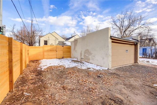 snow covered property with a garage