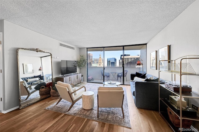 living room featuring expansive windows, hardwood / wood-style floors, and a textured ceiling