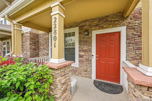 22801 E Briarwood Pl, Aurora, CO 80016 - doorway to property featuring stone siding and a porch