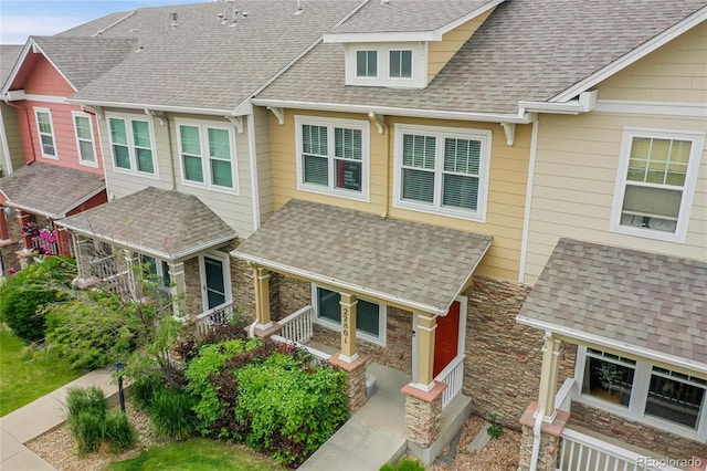 22801 E Briarwood Pl, Aurora, CO 80016 - view of front of house featuring stone siding, a porch, and roof with shingles