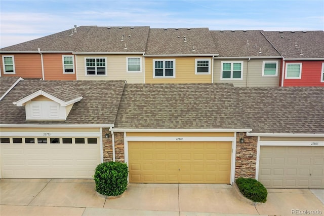22801 E Briarwood Pl, Aurora, CO 80016 - townhome / multi-family property with roof with shingles, stone siding, and a garage