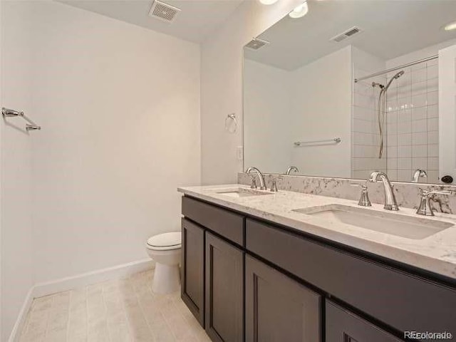 bathroom featuring tile patterned floors, toilet, and dual bowl vanity