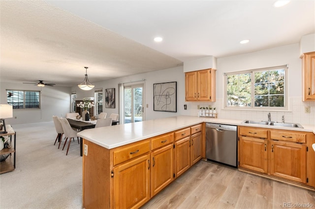 kitchen with dishwasher, hanging light fixtures, kitchen peninsula, ceiling fan, and sink