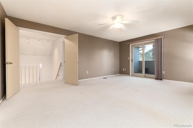 carpeted empty room featuring track lighting, a textured ceiling, ceiling fan, and vaulted ceiling