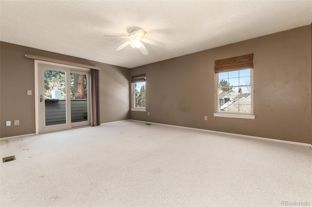 empty room with ceiling fan, a textured ceiling, and carpet flooring