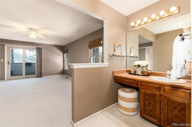 bathroom with a textured ceiling, ceiling fan, vanity, and plenty of natural light