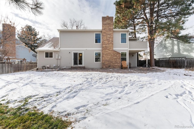 view of snow covered back of property