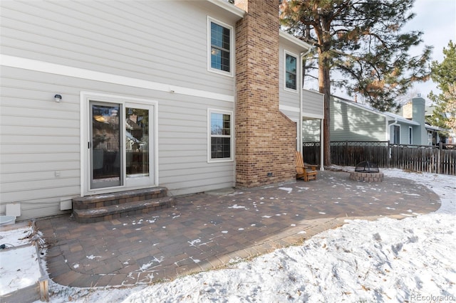 snow covered property with a patio and an outdoor fire pit