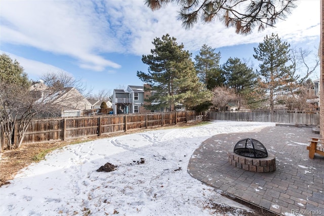 yard layered in snow with an outdoor fire pit